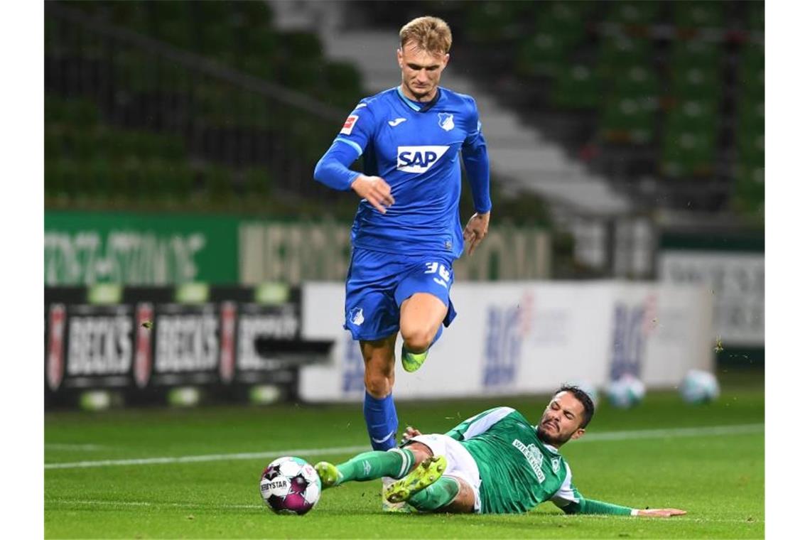 Nach Corona-Wirbel: Werder und Hoffenheim mit Punkteteilung Werders Leonardo Bittencourt (r) versucht Hoffenheims Stefan Posch per Grätsche zu stoppen. Foto: Carmen Jaspersen/dpa