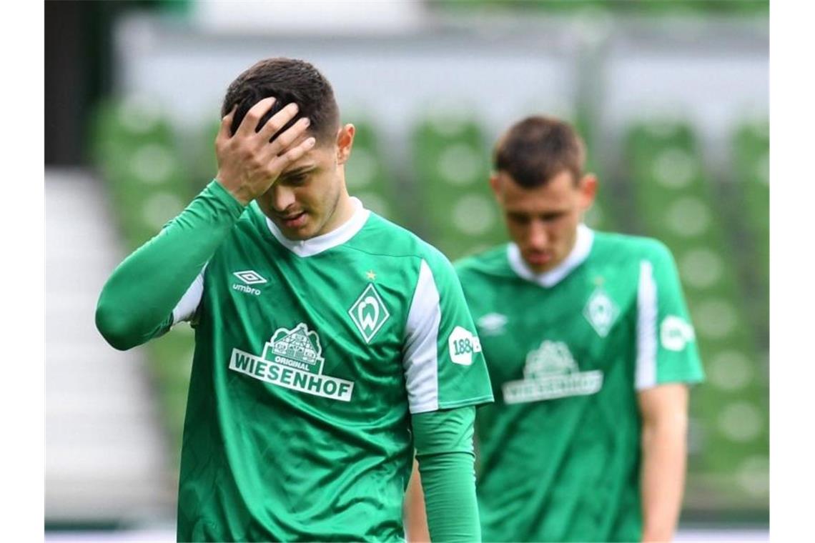 Bremen steigt mit Schalke ab - Union im Europapokal Werders Maximilian Eggestein (hinten) und Milot Rashica gehen nach dem Abstieg mit gesenkten Köpfen vom Platz. Foto: Carmen Jaspersen/dpa