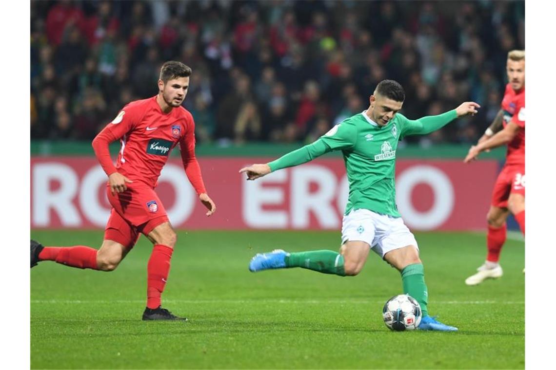 Werders Milot Rashica (r) kämpft gegen Heidenheims Marnon Busch um den Ball. Foto: Carmen Jaspersen/dpa