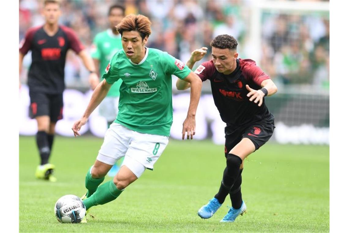 Kohfeldt jubelt mit „Wäschefrau“ - Bremen schlägt Augsburg Werders Yuya Osako (l) setzt sich gegen Augsburgs Ruben Vargas durch. Foto: Carmen Jaspersen