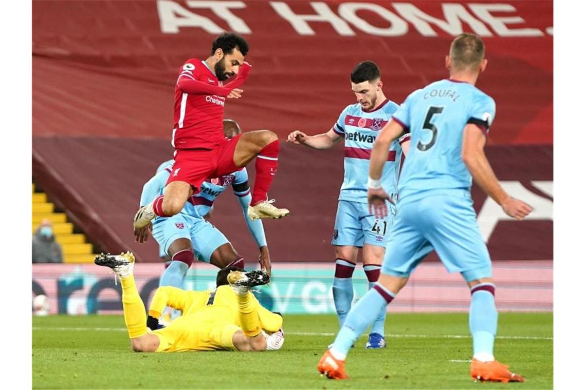 West Ham Uniteds Torwart Lukasz Fabianski(unten) kommt vor Liverpools Mohamed Salah an den Ball. Foto: Jon Super/PA Wire/dpa