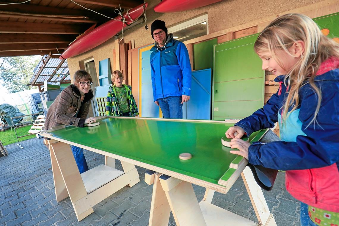 Wie Airhockey mit Holzscheiben: Eisstockschießen ist das beliebteste Spiel von „Bemokaze“. Monika (links) und Bernd Kazenwadel mit ihren Kindern beim Spielen. Foto: A. Becher