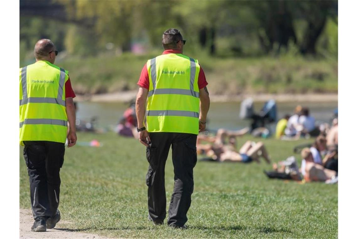 Wie hier am Ufer der Isar wird in München an öffentlichen Orten die Einhaltung der Corona-Regeln kontrolliert. Im Englischen Garten ist es dabei zu einer gewaltsamen Auseinandersetzung zwischen der Polizei und Feiernden gekommen. (Symbolbild). Foto: Peter Kneffel/dpa