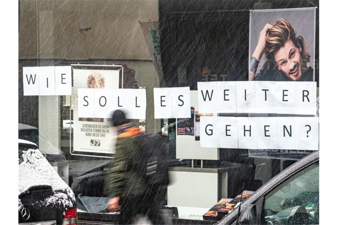 Jeder zweite Deutsche gegen Lockerung des Corona-Lockdowns „Wie soll es weitergehen“ fragen sich angesichts der coronabedingten Schließung mittels eines Schriftzuges im Schaufenster die Inhaber eines Friseursalons in Bad Homburg. Foto: Frank Rumpenhorst/dpa