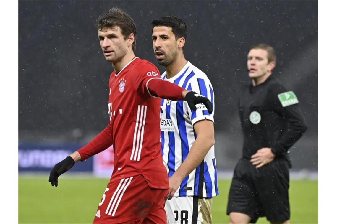 Bayern nach Chaos-Reise in Katar gelandet Wiedersehen zweier Weltmeister: Hertha-Neuzugang Sami Khedira (r) und Bayerns Thomas Müller. Foto: John Macdougall/AFP-Pool/dpa