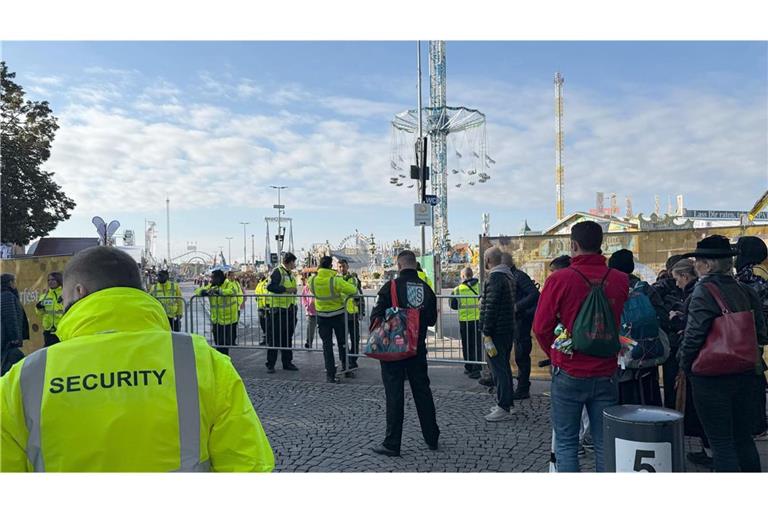 Wiesn-Besucher warten am Mittwochmorgen vor dem abgesperrten Festgelände.