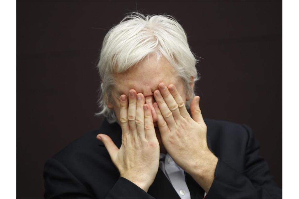 WikiLeaks-Gründer Julian Assange hält die hände vor das Gesicht während einer Pressekonferenz. Foto: Lefteris Pitarakis/AP/dpa