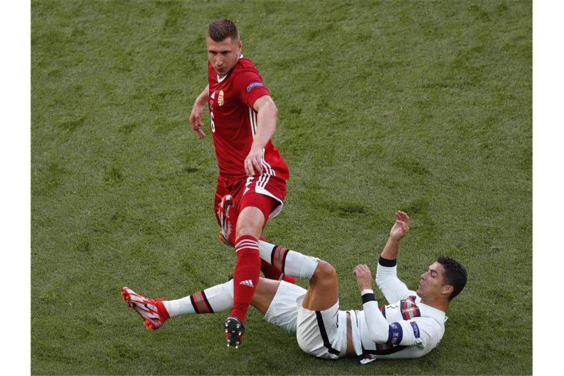 Willi Orban springt über Cristiano Ronaldo. Foto: Laszlo Balogh/AP Pool/dpa