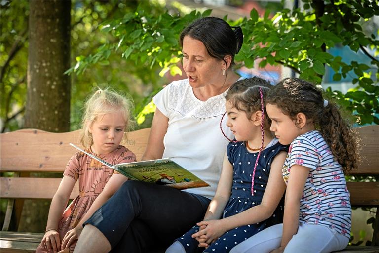 Willkommene Verstärkung in der Kita „Bertha von Suttner“: Sandra-Doreen Steppa-Kiss liest Greta, Meyra und Nisa (von links) ein Bilderbuch vor.Foto: Alexander Becher