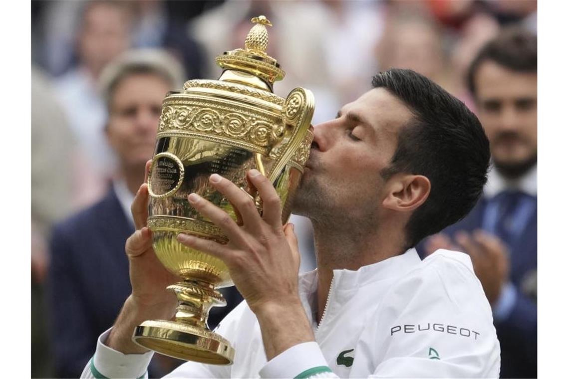 Djokovic stellt in Wimbledon Rekord ein und will mehr Wimbledon-Sieger Novak Djokovic küsst seine Trophäe. Foto: Alberto Pezzali/AP/dpa