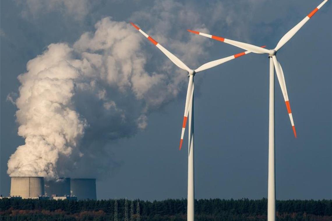 Windräder drehen sich vor den Kühltürmen des Braunkohlekraftwerkes in Jänschwalde (Brandenburg). Foto: Patrick Pleul/dpa-Zentralbild/dpa