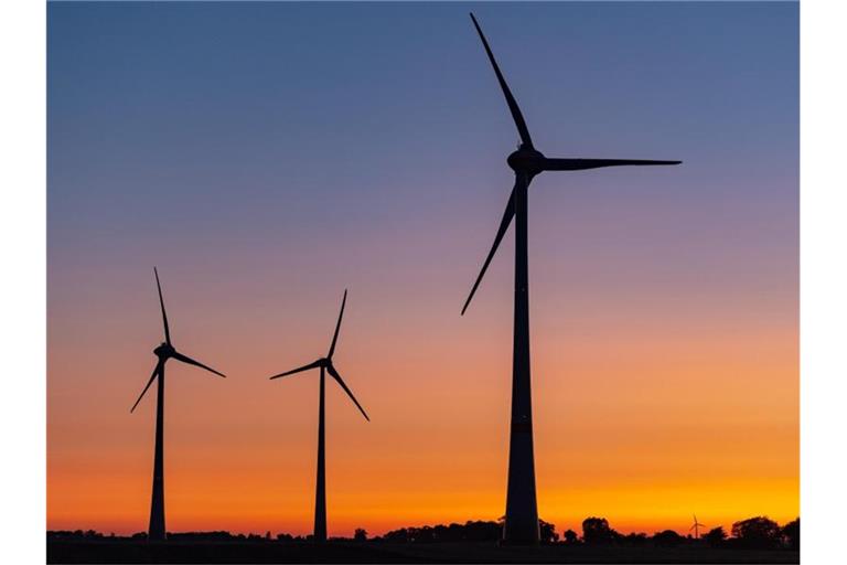 Windräder sind vor einem farbenprächtig leuchtenden Morgenhimmel kurz vor Sonnenaufgang zu sehen. Foto: Patrick Pleul
