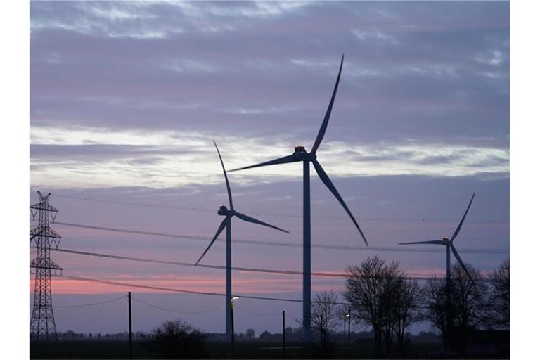 Windräder und Stromleitungen sind im Abendlicht zu sehen. Foto: Marcus Brandt/dpa/Symbolbild