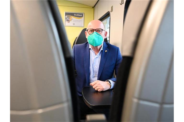 Winfried Hermann (Bündnis 90/Die Grünen) sitzt in einem Zug. Foto: Bernd Weißbrod/dpa/Archivbild