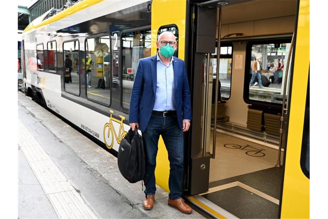 Hermann: „Menschen bei Klimaschutz nicht abschrecken“ Winfried Hermann, Verkehrsminister von Baden-Württemberg, steht im Eingang eines Regionalzugs. Foto: Bernd Weißbrod/dpa