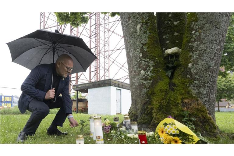 Winfried Hermann, Verkehrsminister von Baden-Württemberg, legt eine weiße Blume in der Nähe einer Unglücksstelle ab.