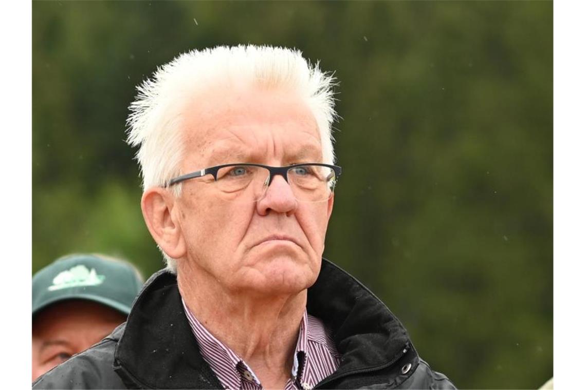 Winfried Kretschmann (Bündnis 90/Die Grünen) greift sich, während einer Waldbegehung, an seine Jacke. Foto: Patrick Seeger