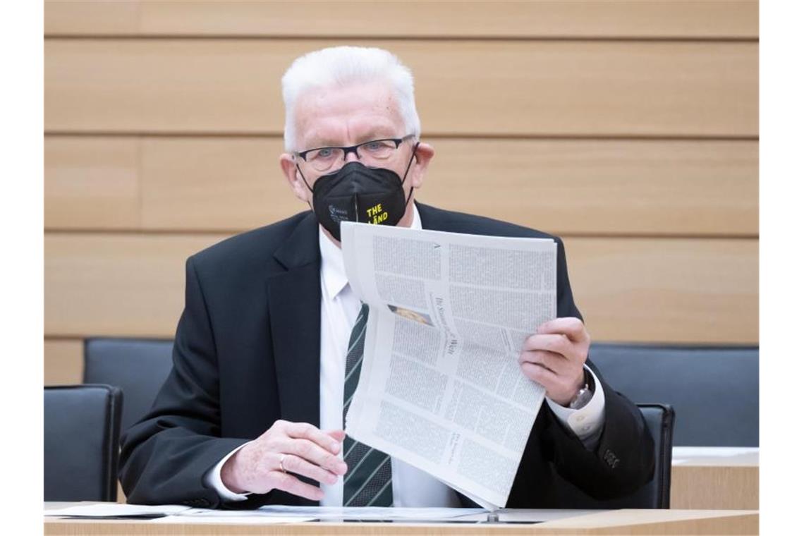 Baden-Württemberg arbeitet an Öffnungsplan für Ende Februar Winfried Kretschmann (Bündnis 90/Die Grünen) legt vor Beginn auf der Regierungsbank eine Zeitung ab. Foto: Bernd Weißbrod/dpa/Archivbild