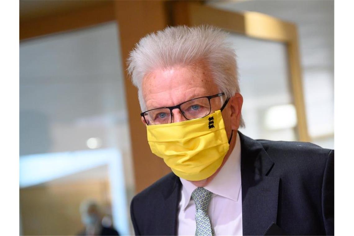 Winfried Kretschmann (Grünen), Ministerpräsident von Baden-Württemberg, kommt während einer Sitzung des Landtags mit Mundschutz. Foto: Sebastian Gollnow/dpa/Archivbild