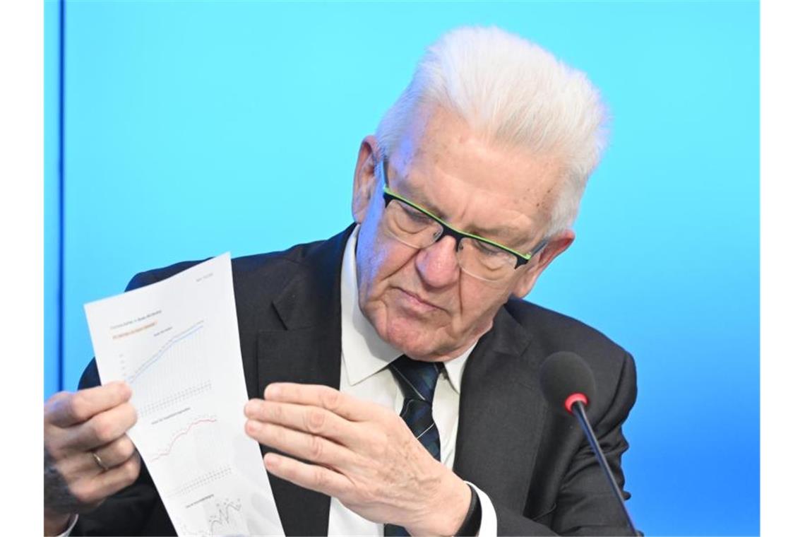 Kretschmann will vorsichtig lockern Winfried Kretschmann zeigt ein Blatt mit Corona-Tabellen auf der Regierungspressekonferenz. Foto: Bernd Weißbrod/dpa