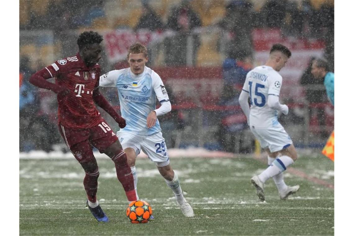 Winterliche Bedingungen erwarteten Bayerns Alphonso Davies (l) und seine Teamkollegen in der Ukraine. Foto: Efrem Lukatsky/AP/dpa