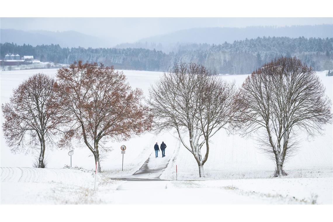 Winterwetter bei Bösingen: Fußgänger auf verschneitem Weg im Schwarzwald.