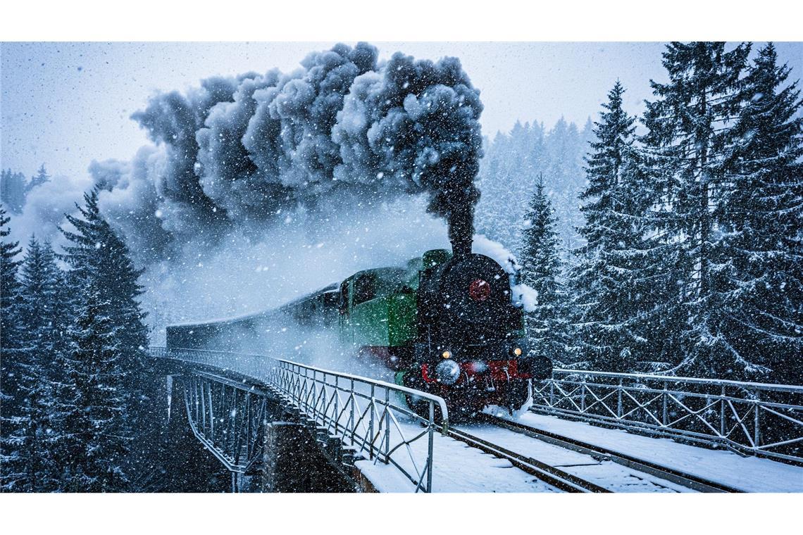 Winterwunderwelt: Eine historische Dampflokomotive fährt in Tschechien durch die verschneite Landschaft.
