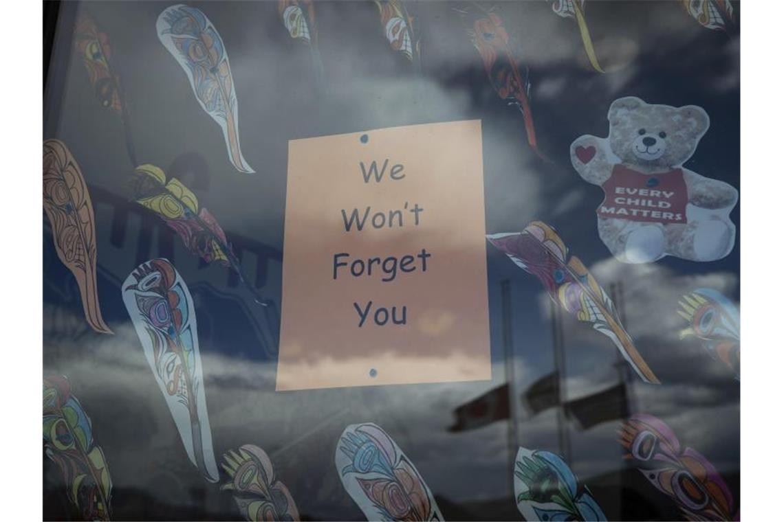 Über 700 Gräber bei weiterer Schule für Indigene entdeckt „Wir werden Euch nicht vergessen“ steht auf einem Plakat im Fenster einer Schule in British Columbia, nachdem dort die Überreste von 215 Kindern gefunden worden waren. Nun sind in Zentralkanada 751 unmarkierte Gräber entdeckt worden. Foto: Darryl Dyck/The Canadian Press/dpa