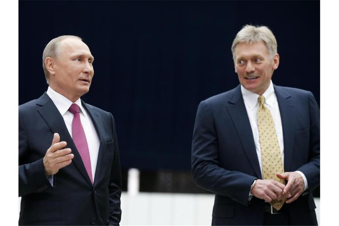 Wladimir Putin (l), Präsident von Russland, spricht neben seinem Sprecher Dmitri Peskow mit Journalisten nach seiner jährlichen Fernsehshow. Foto: Alexander Zemlianichenko/AP/dpa