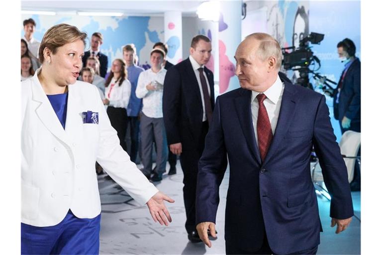 Wladimir Putin (r.), Präsident von Russland, geht neben Natalya Solovei, stellvertretende Direktorin des Okean-Zentrums, bei einem Besuch im gesamtrussischen Bildungszentrum für Kinder. Foto: Sergei Bobylev/TASS/dpa