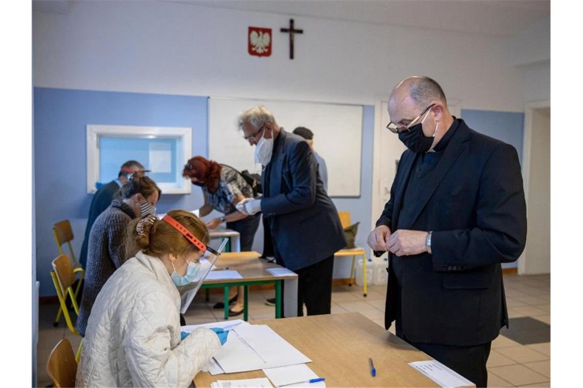 Wojciech Polak (r), Erzbischof von Gnesen und Primas der katholischen Kirche in Polen, gibt seine Stimme ab. Foto: Pawel Jaskolka/PAP/dpa