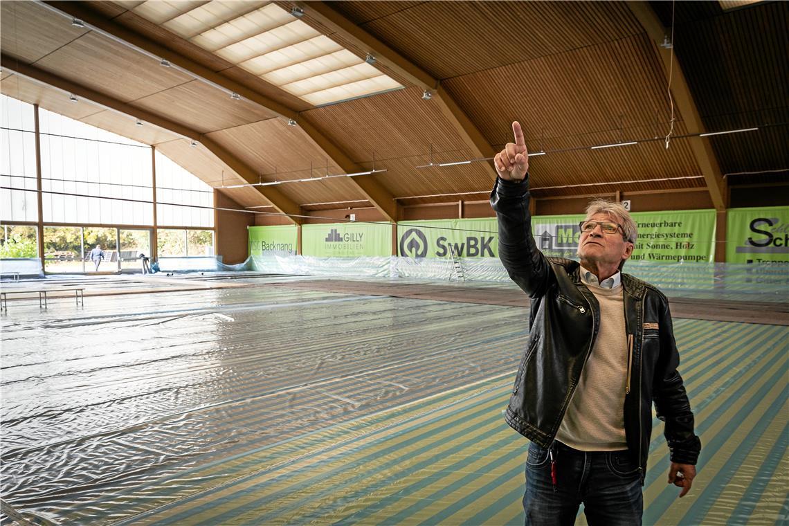 Wolfgang Michel zeigt auf die kaputten Oberlichter der Tennishalle, in der momentan nicht gespielt werden kann. Foto: Alexander Becher