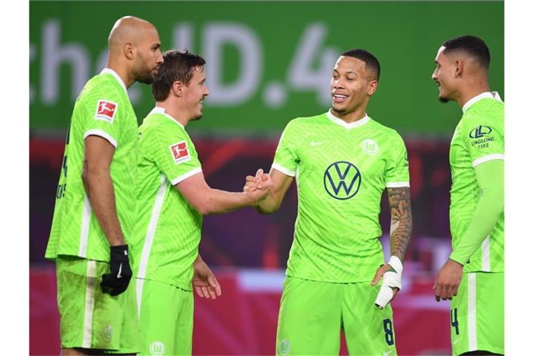 Wolfsburg-Neuzugang Max Kruse (2.v.l.) klatscht nach dem Treffer zum 2:1 mit Aster Vranckx ab. Foto: Swen Pförtner/dpa