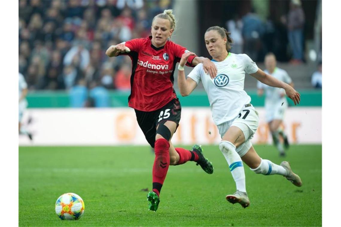 Wolfsburgs Ewa Pajor (r) und Freiburgs Virginia Kirchberger kämpfen um den Ball. Foto: Federico Gambarini/dpa/Archivbild