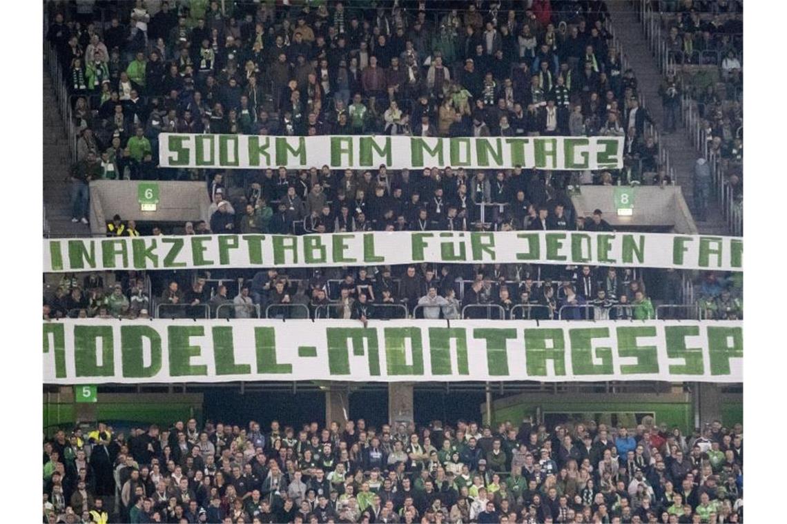 Wolfsburgs Fans halten ein Banner mit Kritik an der Praxis der Montagsspiele hoch. Foto: Peter Steffen
