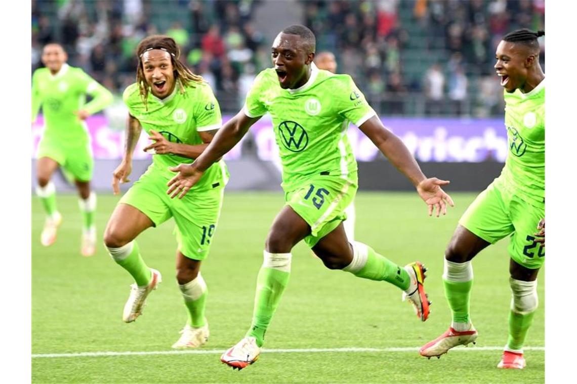 Roussillon schießt Wolfsburg zurück auf Platz eins Wolfsburgs Jerome Roussillon (M) jubelt nach seinem Treffer zum 1:0 mit seinen Teamkollegen Kevin Mbabu (l) und Ridle Baku (r). Foto: Swen Pförtner/dpa