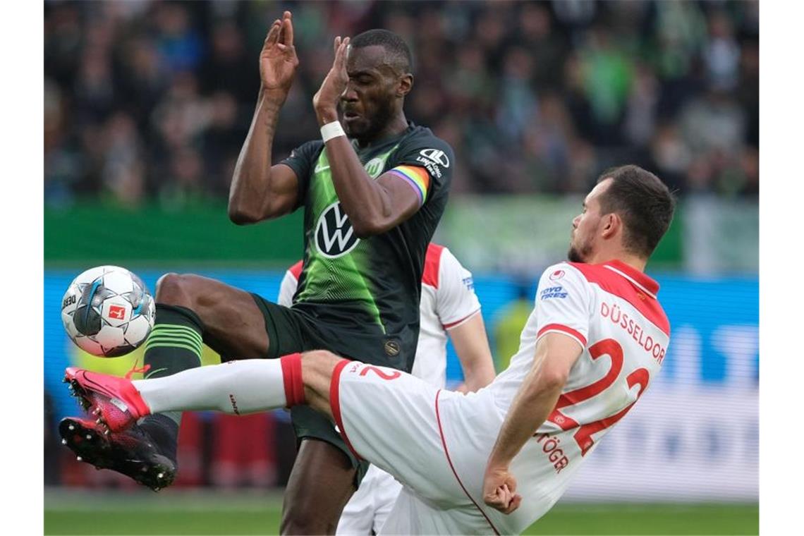 Wolfsburgs Josuha Guilavogui (l) und Düsseldorfs Kevin Stöger teilten sich mit ihren Teams die Punkte. Foto: Peter Steffen/dpa