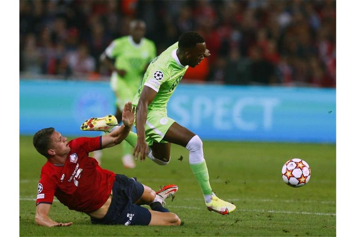 Wolfsburgs Josuha Guilavogui (r) kann sich gegen Sven Botman von OSC Lille durchsetzen. Foto: Michel Spingler/AP/dpa