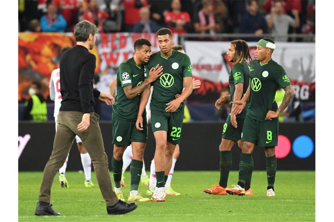 Alarmzeichen: Wolfsburger Zusammenarbeit „verloren gegangen“ Wolfsburgs Trainer Mark van Bommel (l) geht nach dem Spiel über den Platz zu seinen Spielern. Foto: Angelika Warmuth/dpa