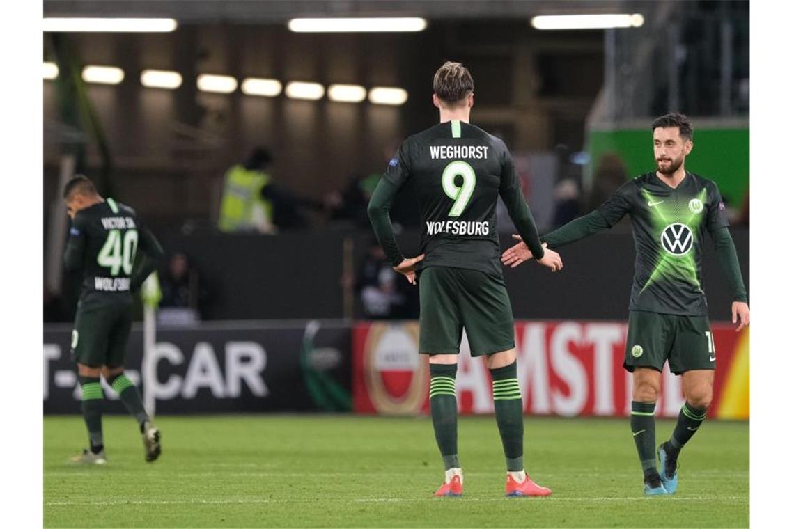 Wolfsburgs Victor Joao (l-r), Wout Weghorst und Yunus Malli stehen nach dem Spiel gegen Gent auf dem Rasen. Foto: Peter Steffen/dpa