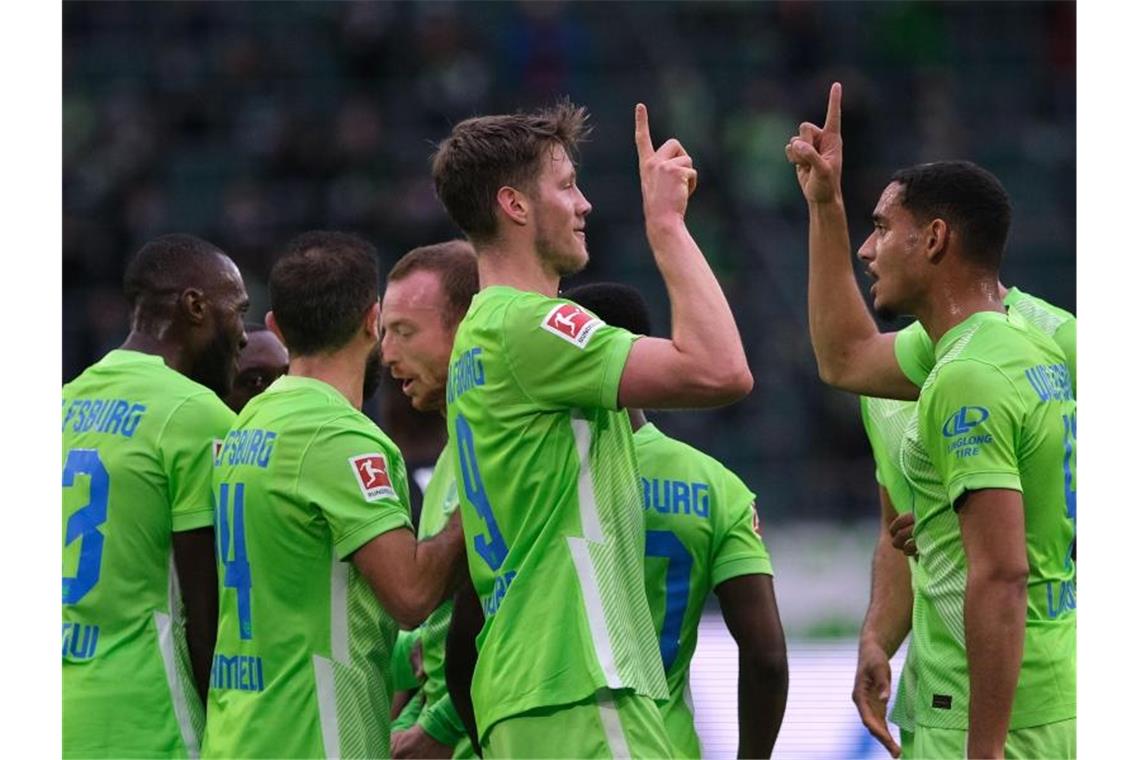 Wolfsburgs Wout Weghorst (M) bejubelt sein Tor zum 1:0 gegen Arminia Bielefeld mit Mannschaftskamerad Maxence Lacroix (r). Foto: Peter Steffen/dpa