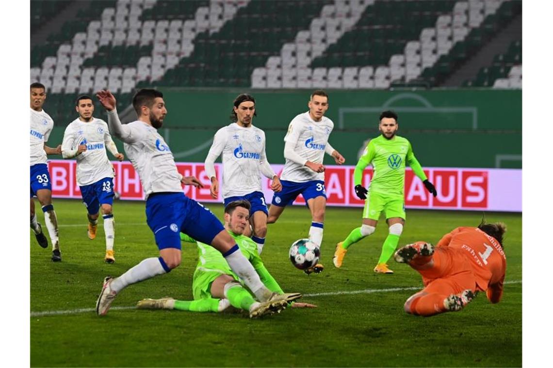 Wolfsburgs Wout Weghorst (M) erzielt gegen Schalkes Torwart Ralf Fährmann (r) das 1:0. Foto: Swen Pförtner/dpa