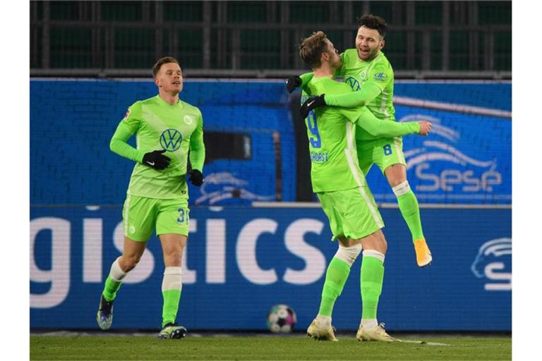Wolfsburgs Wout Weghorst (M) jubelt mit den Mannschaftskameraden Renato Steffen (r) und Yannick Gerhardt nach seinem Tor zum 2:0. Foto: Swen Pförtner/dpa