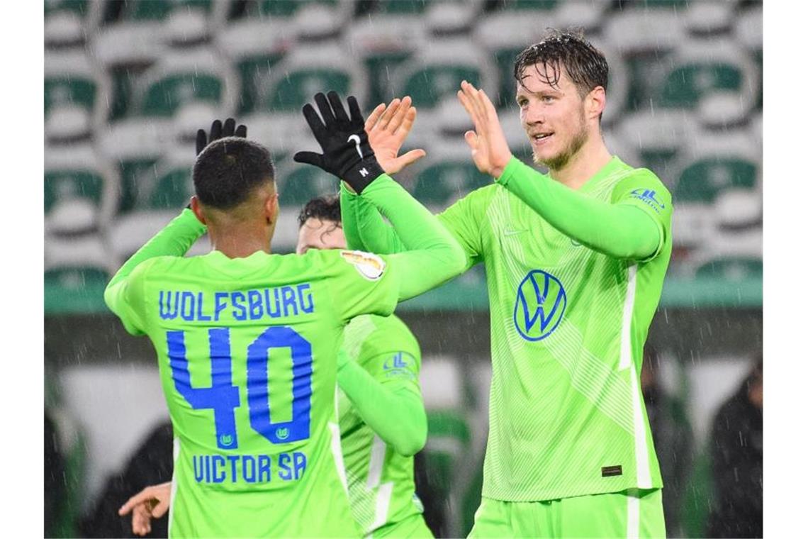 Wolfsburgs Wout Weghorst (r) klatscht nach seinem Tor zum 2:0 mit Mannschaftskamerad Joao Victor ab. Foto: Swen Pförtner/dpa