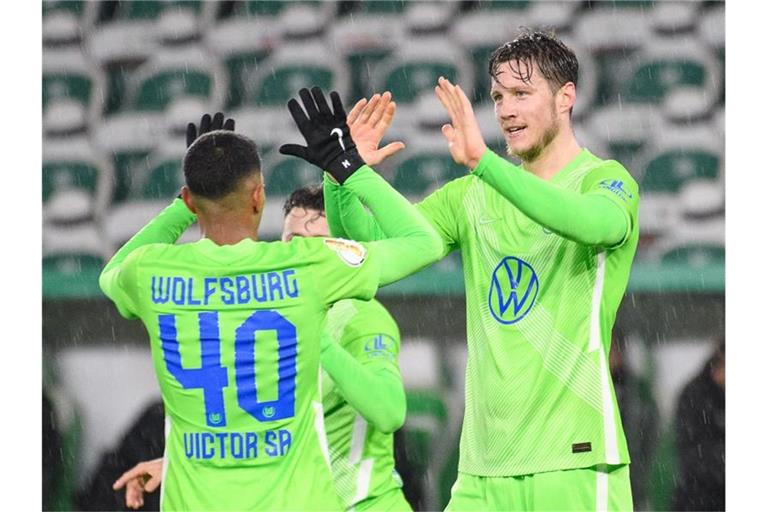 Wolfsburgs Wout Weghorst (r) klatscht nach seinem Tor zum 2:0 mit Mannschaftskamerad Joao Victor ab. Foto: Swen Pförtner/dpa