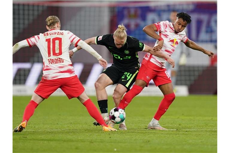 Wolfsburgs Xaver Schlager (M) im Zweikampf mit den Leipzigern Christopher Nkunku (r) und Emil Forsberg. Foto: Michael Sohn/AP-Pool/dpa