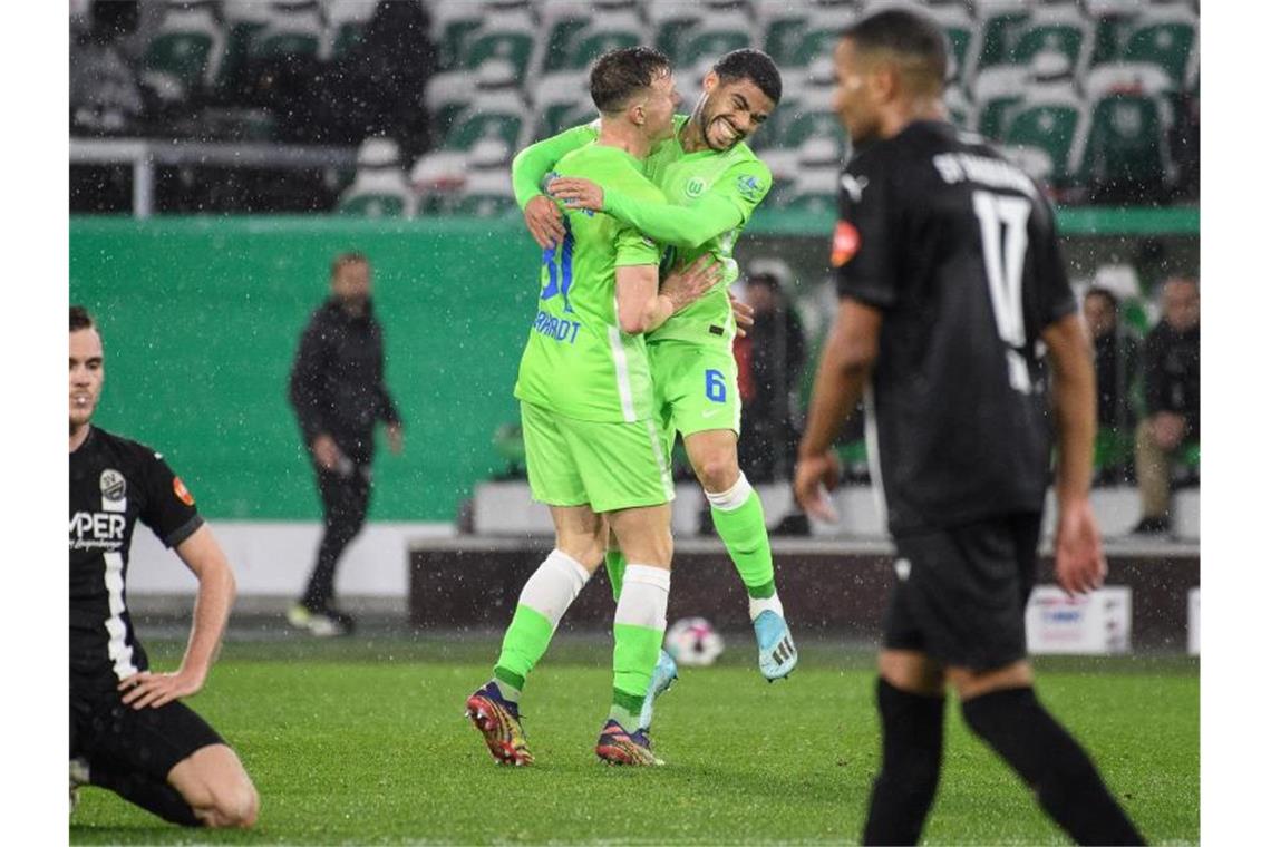 Wolfsburgs Yannick Gerhardt (M) jubelt mit Paulo Otavio nach seinem Tor zum 1:0. Foto: Swen Pförtner/dpa