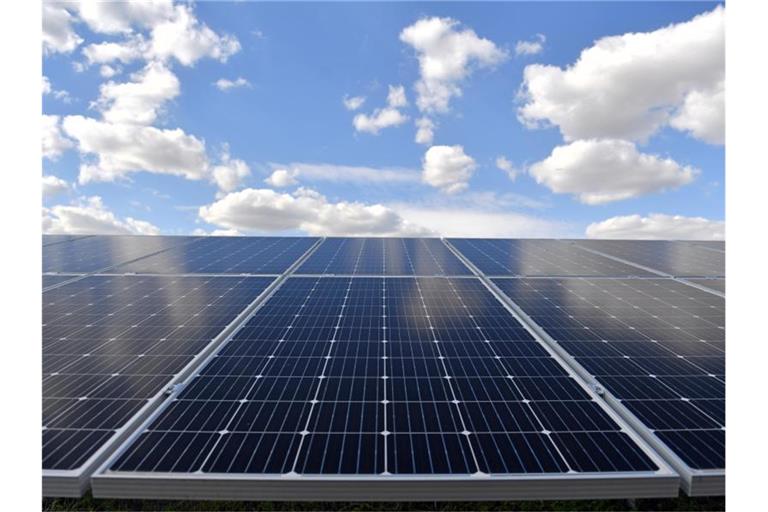 Wolken stehen am blauen Himmel über einem Solarpark. Foto: Hendrik Schmidt/dpa-Zentralbild/dpa/Archiv