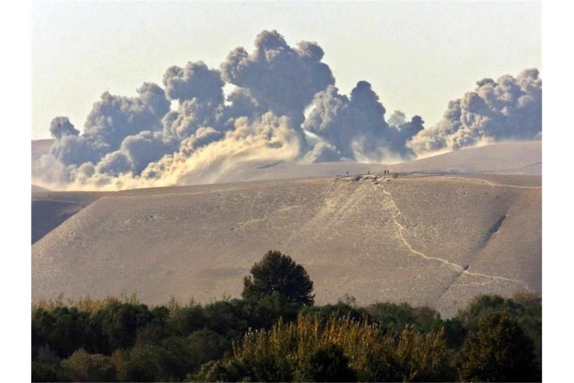 Wolken von Rauch und Staub nach einem US-Luftangriff auf Taliban-Kräfte in den Qala Cata Bergen in Nordafghanistan im November 2001. Foto: Sergei_Chirikov/epa/dpa