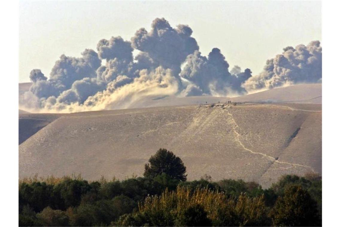 Taliban begrüßen Beginn des Truppenabzugs aus Afghanistan Wolken von Rauch und Staub nach einem US-Luftangriff auf Taliban-Kräfte in den Qala Cata Bergen in Nordafghanistan im November 2001. Foto: Sergei_Chirikov/epa/dpa